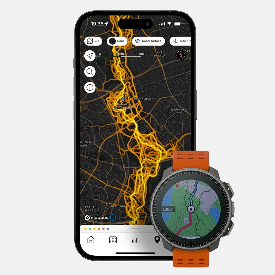 Image of a smartphone and a smartwatch displaying outdoor navigation tools. The phone screen shows a dark-mode heatmap of popular routes in Helsinki, Finland, using the Suunto app with Mapbox integration. Bright yellow and orange lines indicate frequently traveled paths. The smartwatch, a Suunto Vertical with an orange band, displays a topographic map with a route, compass arrow, and distance marker. The setup illustrates advanced GPS tracking and route planning for runners, hikers, or mountaineers.