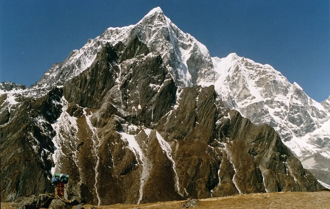 Striking view of Lobuche East's rugged, snow-streaked summit towering under a clear blue sky in Nepal's Everest region.