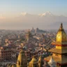 Panoramic sunset view over Kathmandu Valley with historic temples and Himalayan snow peaks in the background