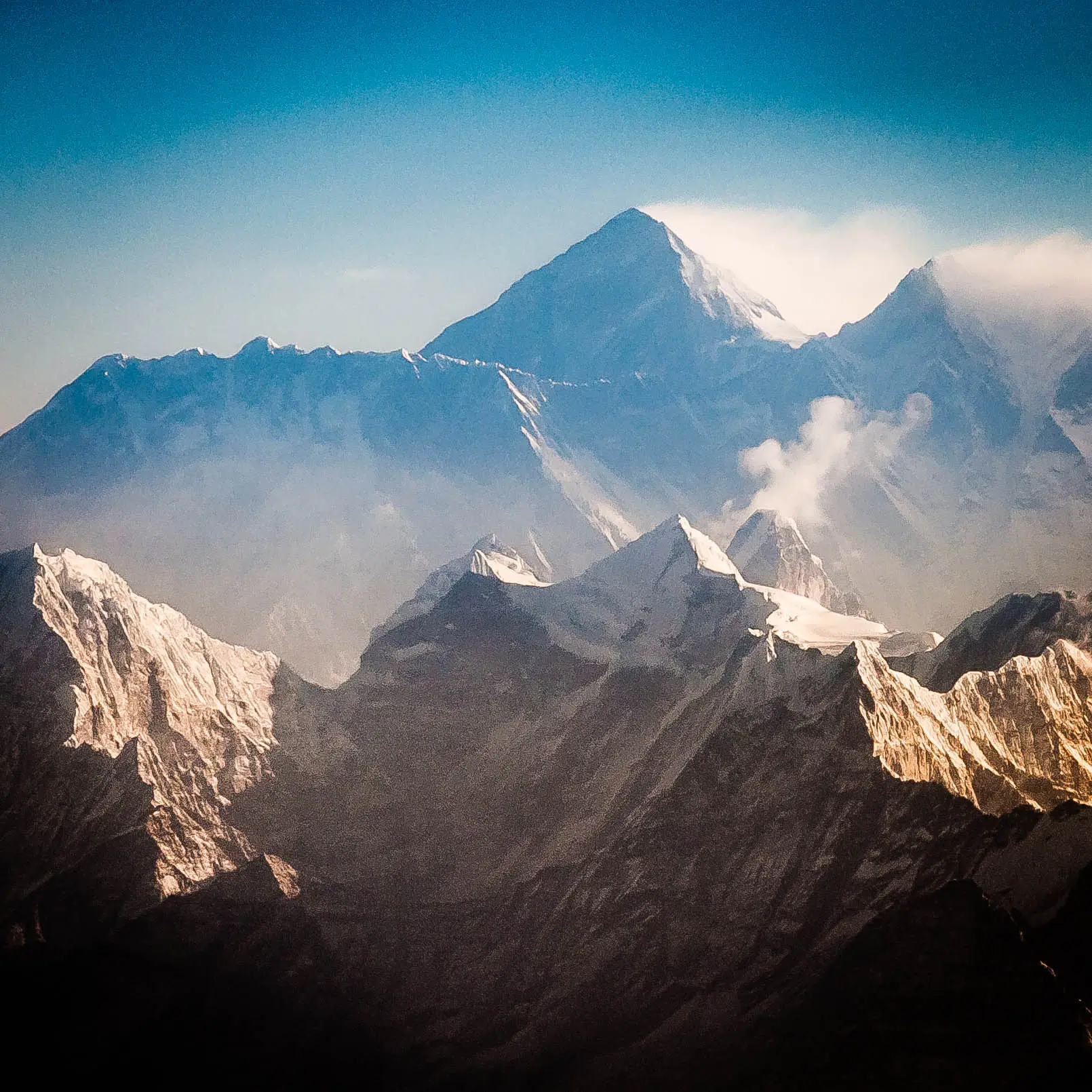 View from the south (Nepal) shows Everest rising behind the ridge connecting Nuptse and Lhotse; in the foreground are Thamserku, Kangtega, and Ama Dablam,